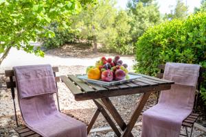 un piatto di frutta su un tavolo con due sedie di Hotel Vilar Rural d'Arnes by Serhs Hotels a Arnés