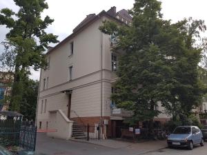 una casa blanca con un coche aparcado delante de ella en Nest Apartment en Sopot