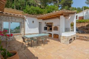 um pátio com uma mesa e uma lareira de pedra em VILLA JEROME em Palafrugell