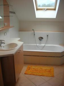 a bathroom with a bath tub and a sink at Ferienwohnung Kogler in Strobl