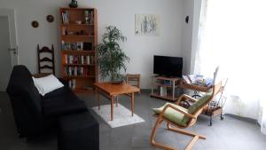 a living room with a couch and chairs and a tv at Homal in Konstanz