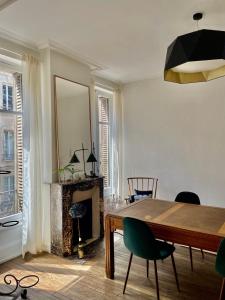 une salle à manger avec une table et une cheminée dans l'établissement Cœur de ville, appartement de caractère, à Nancy