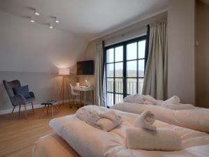 a hotel room with three beds with towels on them at Reetland am Meer - Premium Reetdachvilla mit 3 Schlafzimmern, Sauna und Kamin F27 in Dranske
