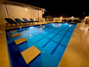 a swimming pool at night with chairs around it at La Boutique Residence in Hurghada