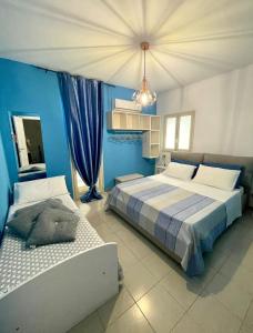 1 dormitorio con 2 camas y pared azul en Villa Priscilla en Cinisi