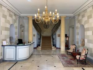 a large lobby with a chandelier and a staircase at Le Manoir de Bellerive in Le Buisson de Cadouin