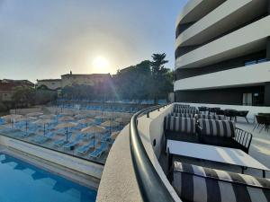 贝西奇Montenegrina Hotel & SPA All-Inclusive的建筑物旁边有带椅子和遮阳伞的游泳池