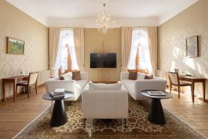 ein Wohnzimmer mit weißen Möbeln und einem TV in der Unterkunft Schloss Fellin Boutique Hotel and Spa in Viljandi