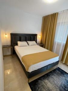a bedroom with a large bed with a large window at Villa Scandinavia in Mostar