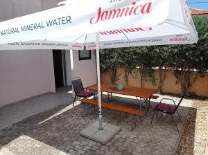 une table et des chaises sous un parasol blanc dans l'établissement Anita, à Zadar