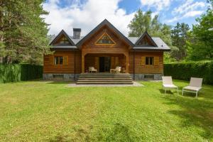 una casa in legno con un cortile con sedie di fronte di CASA RURAL PICO ASPE a Villanúa