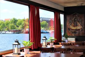 a restaurant with tables and a view of the river at Amice in Haarlem