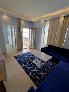 a living room with a blue couch and a table at La Boutique Residence in Hurghada