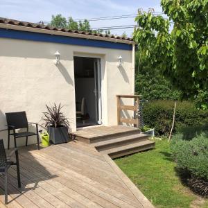 a wooden deck in the yard of a house at Maison Marin, Charming Village Cottage with Pool in Saint-Thomas-de-Cônac