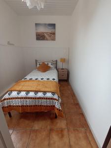 a bedroom with a bed and a tiled floor at Maison Marin, Charming Village Cottage with Pool in Saint-Thomas-de-Cônac +4 photos