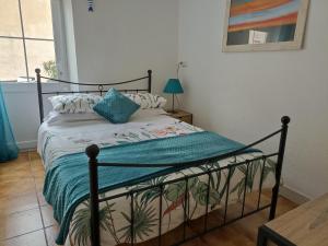 a bedroom with a bed with a green blanket at Maison Marin, Charming Village Cottage with Pool in Saint-Thomas-de-Cônac