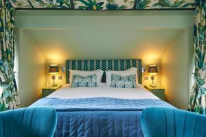 a bedroom with a bed and two blue chairs at Hotel du Vin Exeter in Exeter