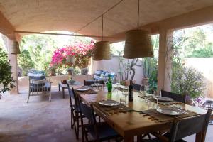 a dining room with a long table and chairs at Casa Muro Luxury Villa in Cala Saona