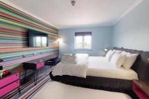 a hotel room with two beds and a tv at Village Hotel Bournemouth in Bournemouth
