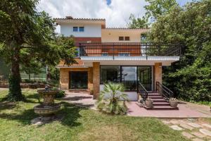 a large house with a balcony on top of it at L'aviador de Can Ton, in the middle of nature with its own stream in Sant Llorenc Savall