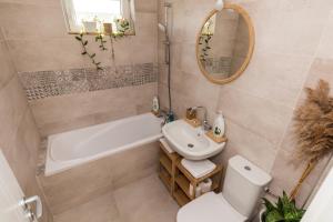 a bathroom with a sink and a tub and a toilet at Apartamentul cu plante Etaj 4 in Mangalia