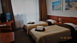 a hotel room with two beds and a flat screen tv at San Medical Spa in Kołobrzeg