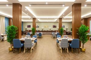 BaishにあるLe Park Concord Hotel Baishのテーブルと椅子、植物のある宴会場