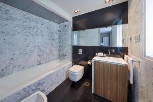 a bathroom with a sink and a toilet and a tub at Hyatt Regency Madrid Residences in Madrid