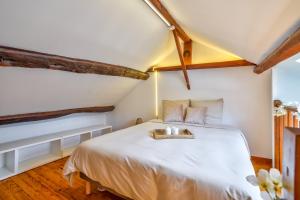 Un dormitorio con una cama blanca y una bandeja. en Sospa - Suite spa privatif, en La Falaise