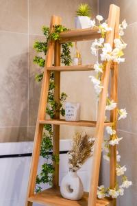 ein Holzregal mit Blumen und Pflanzen darauf in der Unterkunft Sospa - Suite spa privatif in La Falaise