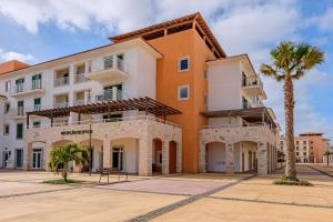 a building with a palm tree in front of it at Agua Hotels Sal Vila Verde in Santa Maria