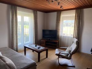 a living room with a couch and a tv at Holiday apartment in St Kanzian on Lake Klopein in Srejach