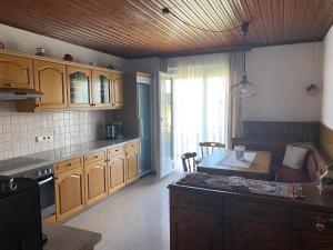 a kitchen with wooden cabinets and a table in it at Holiday apartment in St Kanzian on Lake Klopein in Srejach