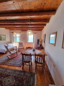 uma sala de estar com uma mesa de madeira e cadeiras em Apartment Ružica em Tribunj
