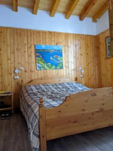 a bedroom with a bed in a wooden room at La casetta nel bosco in Salò