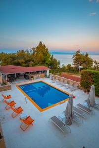 une grande piscine avec des chaises et une piscine. dans l'établissement Maya Bay, à Kallithéa Halkidikis