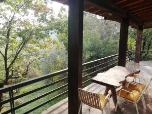 una mesa y sillas en un porche con vistas al bosque en La casetta nel bosco, en Saló
