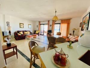 a living room with a couch and a table and chairs at Beautiful house on the beachfront in Costa tropical in Calahonda