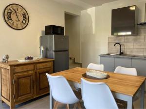 a kitchen with a wooden table and a clock on the wall at PROGÎTES "Le Cottage" in Quiévrain