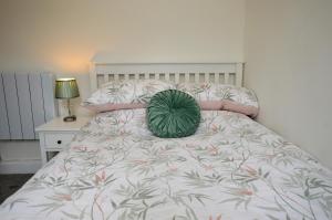 a bed with a green pillow on top of it at Findhorn Upper Apartment in Kames