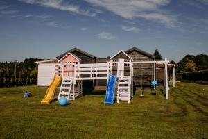 a house with a playground with a slide at Domki Energylandia Zator Przybradz in Przybradz