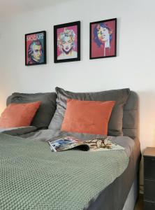 a bed with three pictures on the wall above it at Neues City Center Piano Appartement mit Netflix in Klagenfurt