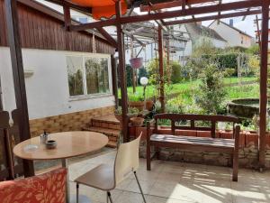 a patio with a table and chairs and a bench at Parkplätze, Einzelbetten, 2 TVs, Balkon, Terrasse, fast Wi-Fi bis zu 1000 Mbit, Homeoffice in Rodenbach