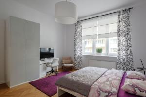 een slaapkamer met een bed, een bureau en een raam bij Apartamenty Starowiejska 37 in Gdynia