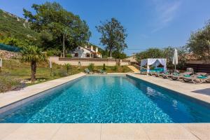 a swimming pool in the backyard of a house at Villa Valentina - Luxurious holiday for 9 people with xxl pool and whirpool in Bribir