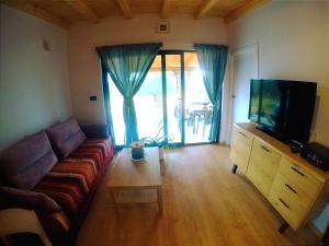 een woonkamer met een bank en een flatscreen-tv bij Nature Home Eco-friendly Pet-friendly in Fažana