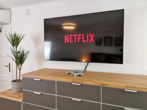 a television on a wall with a netflix sign on it at Neues City Center Piano Appartement mit Netflix in Klagenfurt