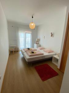 Un dormitorio con una cama grande y una alfombra roja en Arthouse Surf Ericeira, en Ericeira