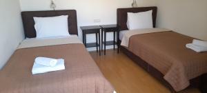 two beds in a small room with two tables at Anita apartment in Medulin