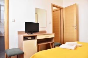 a bedroom with a bed and a tv on a desk at Apartments Stone Tučepi in Tučepi